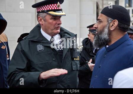 Londres, Royaume-Uni. 24 Décembre 2012 Un agent de police demande à Anjem Chowdary pour désactiver le haut-parleur utilisé dans le cadre d'un rassemblement musulmans radicaux à l'extérieur de la cathédrale de St Paul, après il y a eu plus de 30 plaintes de la personnes en attente d'entrer dans la cathédrale. Le groupe de musulmans s'étaient rassemblés devant la cathédrale et installent des stands et ont distribué des tracts. Il y a eu plusieurs plaintes aux officiers de la proximité d'attente pour entrer dans la Cathédrale St Paul où ils fréquentaient un service. Banque D'Images