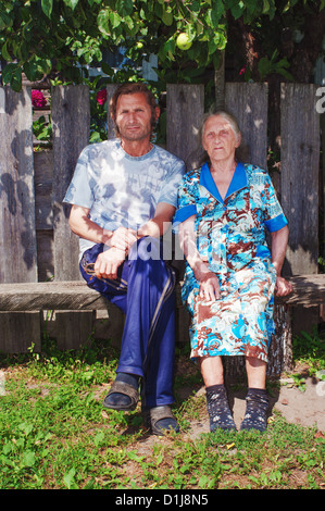 La mère et le fils s'asseoir sur un banc dans le village près de la maison. Banque D'Images