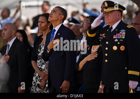 Le président américain Barack Obama regarde vers le ciel comme Air Force F-22 Raptors effectuer la formation de l'homme manquant en l'honneur du sénateur Daniel Inouye pendant un service commémoratif au National Memorial Cemetery of the Pacific, le 23 décembre 2012 à Honolulu, HI. Banque D'Images