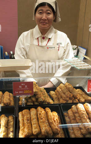 Vente Vente d'une femme sous les grignotines frites à une gare ferroviaire au Japon Banque D'Images