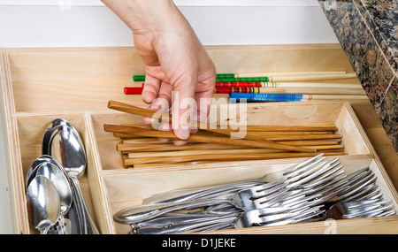 Femme cueillette à la main en bois de baguettes de tiroir de cuisine Banque D'Images