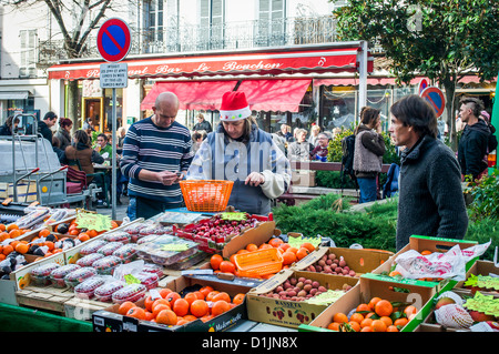 Fruits et légumes de Noël vendeur wearing a Santa hat au marché le samedi à St Girons, Midi-Pyrenees, France. Banque D'Images