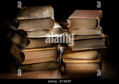 Sombre et moody photographie de deux piles de vieux livres anciens usés. Banque D'Images