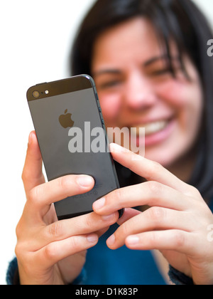 Smiling young woman texting on un iPhone 5 Banque D'Images