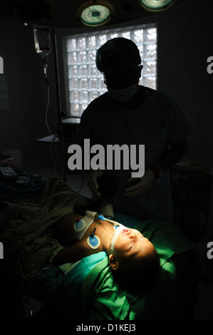 Un jeune enfant couché dans une salle d'opération après la chirurgie pour réparer une fissure dans son palais mou, Bali, Indonésie. Banque D'Images