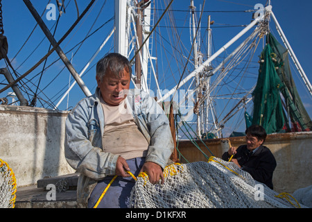 Biloxi, Mississippi - crevettes aux pêcheurs de travailler sur leurs filets amarrée sur le dos de Biloxi Bay. Banque D'Images