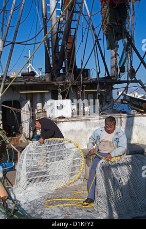 Biloxi, Mississippi - crevettes aux pêcheurs de travailler sur leurs filets amarrée sur le dos de Biloxi Bay. Banque D'Images