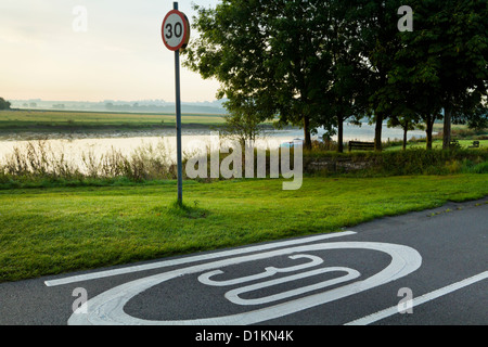 Les panneaux de limite de vitesse de 30 mi/h. 30mph signe sur un panneau et peint sur une route de campagne, Lancashire, England, UK Banque D'Images