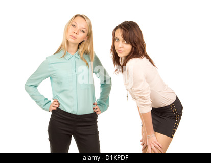 Deux atrractive smiling young women standing ayant un chat, trois quart studio portrait on white Banque D'Images