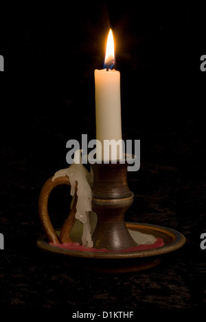 Bougie dans old fashioned porte-chandelier sur fond noir Banque D'Images