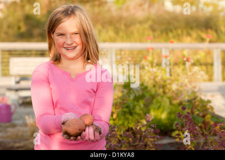 Caucasian girl holding pommes de terre au jardin