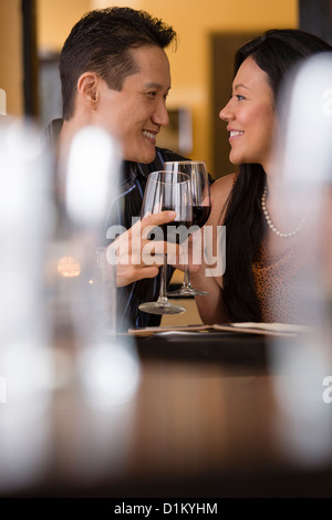 Couple toasting with red wine in restaurant Banque D'Images