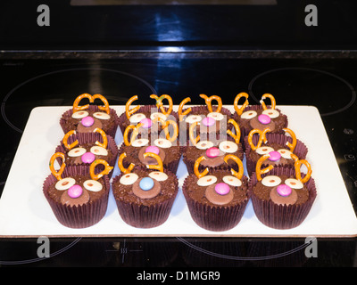 Un bac de chocolat gâteaux de fées avec faces en amusant avec boutons chocolat Banque D'Images