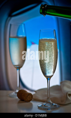 Champagne français fraîchement coulé dans le vol en avion de luxe cabine avec fenêtre et l'aile derrière Banque D'Images