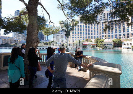 Les touristes de prendre des photos à l'extérieur de l'hôtel Bellagio et casino Las Vegas NEVADA USA Banque D'Images