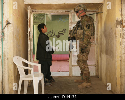 Le sergent de l'armée américaine. William Russell (à droite) membre de l'équipe des forces de sécurité pour l'Équipe provinciale de reconstruction (EPR) Farah parle avec un garçon afghan au cours d'un chef de l'engagement dans la ville de Farah, le 29 décembre. PRT Farah a pour mission de former, de conseiller et d'aider les dirigeants du gouvernement afghan à l'échelle municipale, du district et de la province dans la province de Farah, l'Afghanistan. Leur équipe militaire civil est constitué de membres de la Marine américaine, l'armée américaine, le Département d'État des États-Unis et de l'Agence pour le développement international (USAID). Photo de la Marine américaine Banque D'Images