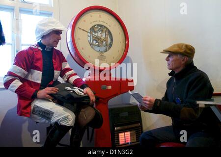 Un jockey portant son soie rouge et blanc dans la balance avant une course. Banque D'Images