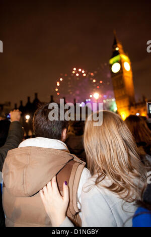 Célébrations du Nouvel An, Westminster, London, UK.01.01.2013 un couple profitez de l'artifice parmi la foule dans le centre de Londres pour célébrer la nouvelle année arriver à regarder le feu d'artifice dans le cadre de Big Ben, Westminster, London, UK Banque D'Images