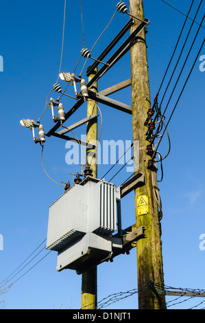 Transformateur d'électricité sur deux mâts en bois. Banque D'Images