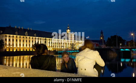 Wroclaw, Pologne, les jeunes filles assis sur les rives de l'Oder, en face de l'université de Breslau Banque D'Images