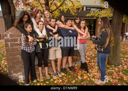 Californie multi-ethnique des élèves du secondaire posent pour une camarade de caméra sur le campus en plein air de l'école. Banque D'Images