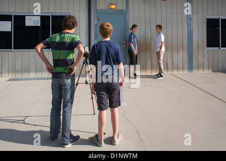 Multi-ethnic preteen garçons travaillent ensemble pour faire une vidéo à leur San Clemente, CA, l'école intermédiaire. Banque D'Images