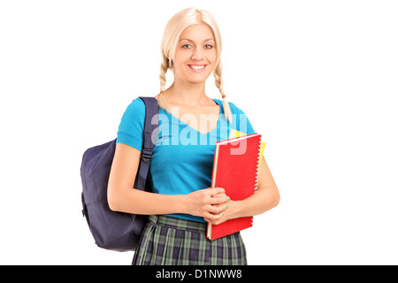 Une élève debout avec sac d'école et la tenue de livres, isolé sur fond blanc Banque D'Images