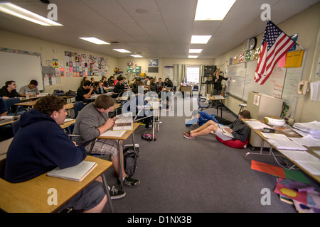 Un professeur de français à l'école Haute Californie sièges étudiants bruyants sur le sol pour éviter de perturber sa classe. Banque D'Images