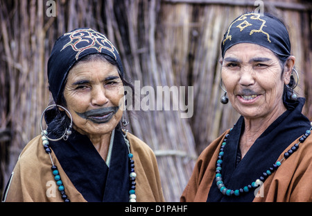 Deux femmes Ainu âgées montrent leurs vêtements traditionnels, bijoux, et tatouages d'enfance sur leurs visages en 1962 sur l'île d'Hokkaido au Japon. Banque D'Images