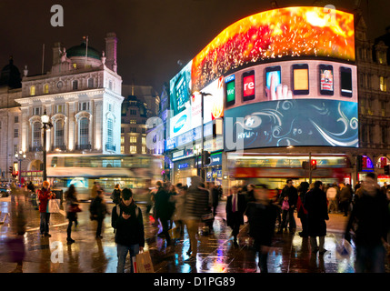 Les gens et les bus de Londres sur une longue nuit dans Piccadilly Circus centre de Londres Angleterre GO UK EU Europe Banque D'Images