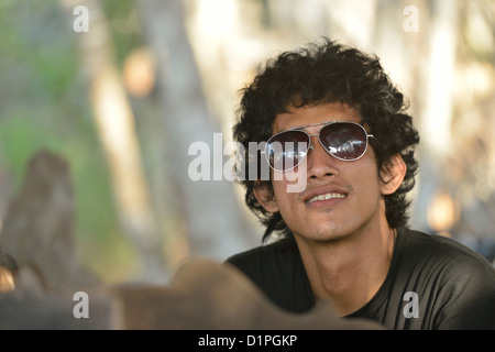 Un jeune mec avec un macaque sur la gauche, en arrière-plan dans l'île de Gili Trawangan, Lombok, Indonésie. Banque D'Images