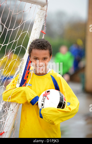 Un garçon de l'école de football un but à la fin d'un match hors plu à Notre Dame et St Werburgh's Catholic Primary Sc Banque D'Images