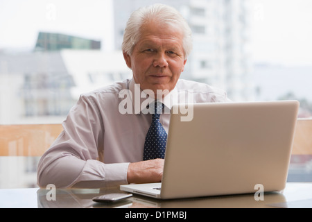 Chilean businessman sitting at desk with laptop Banque D'Images