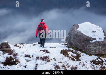 Un female hiker retourner à Glas-Leitire na Paradise dans la neige sur une journée l'hiver au-dessus de Loch Maree, les Highlands écossais. Banque D'Images