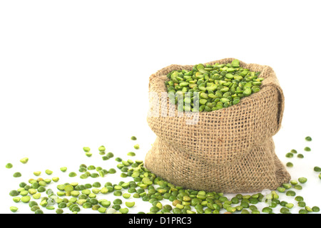 Petits pois secs Split en sac de jute sur blanc (Selective Focus, Focus sur les pois dans l'avant dans le sac) Banque D'Images