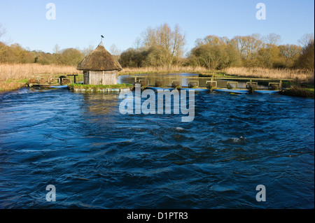 Toit de chaume fishermans hut et pièges de l'autre côté de la rivière Eel, Test Longstock, Hampshire, England, UK Banque D'Images