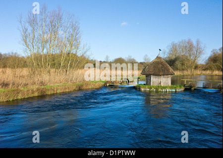 Test de la rivière, Longstock, Hampshire, England, UK - toit de chaume fishermans hut et les pièges de l'anguille Banque D'Images