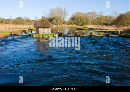 Test de la rivière, Longstock, Hampshire, England, UK - toit de chaume fishermans hut et les pièges de l'anguille Banque D'Images