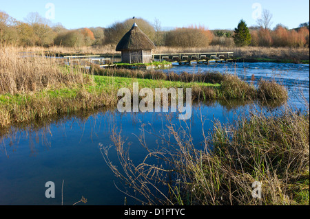 Test de la rivière, Longstock, Hampshire, England, UK - toit de chaume fishermans hut et les pièges de l'anguille Banque D'Images