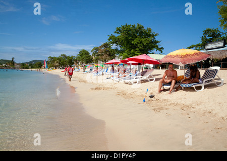 Les touristes à prendre le soleil sur la plage de Reduit, Sainte-Lucie, Caraïbes, Antilles Banque D'Images
