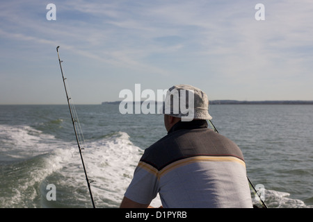 L'homme pour la pêche basse mer avec la tige et la ligne de bateau en Manche Banque D'Images