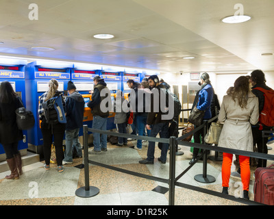 Les voyageurs d'acheter des billets de train New Jersey Transit à libre service distributeur automatique, Penn Station, NYC Banque D'Images