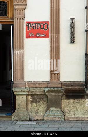 Publicité enseignes tours et un salon de tatouage sur la façade de l'édifice colonial espagnol sur la Calle Alcala Oaxaca Mexique Macedonio Banque D'Images