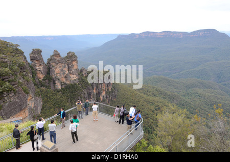 Les touristes se tenir sur l'un de l'écoute qui platfooms à Echo Point dans les Blue Mountains avec vue sur le rocher connu sous le nom les trois Sœurs. Katoomba, New South Wales, Australie. Banque D'Images
