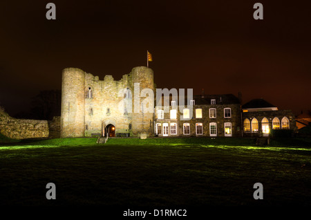 Tonbridge Castle en hiver illuminé par spot light et saisonniers de fête lueur rouge dans le ciel contre châtelet d'entrée d'un drapeau Banque D'Images