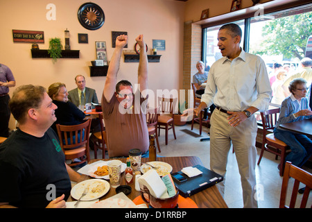 Un mécène à connexion Café réagit en célébration après le président américain Barack Obama lui a donné une bouteille de bière de la Maison blanche au cours d'une campagne s'arrêter le 14 août 2012 dans la région de Knoxville, Iowa. Banque D'Images