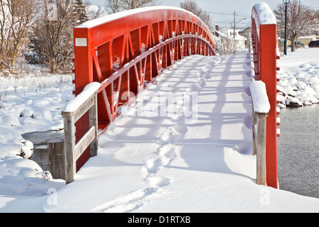 Une passerelle enjambe un petit espace de l'eau dans le paysage d'hiver. Banque D'Images