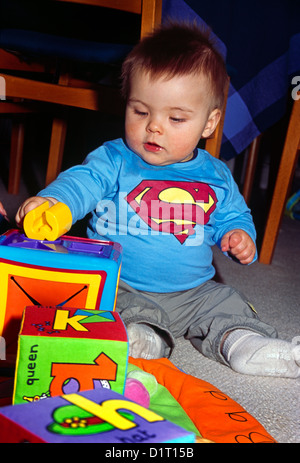 Baby Boy Sitting on Floor Playing With Toy Banque D'Images