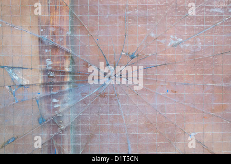 Verre de sécurité cassé avec des fissures qui rayonnent vers l'extérieur dans une formation web spiders Banque D'Images