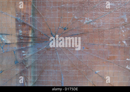 Verre de sécurité cassé avec des fissures qui rayonnent vers l'extérieur dans une formation web spiders Banque D'Images